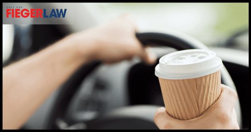 driver holding coffee cup