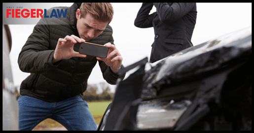 man taking a picture of damages after an accident