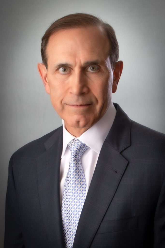 a man wearing a suit and tie looking at the camera