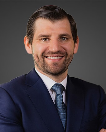 a man wearing a suit and tie smiling at the camera