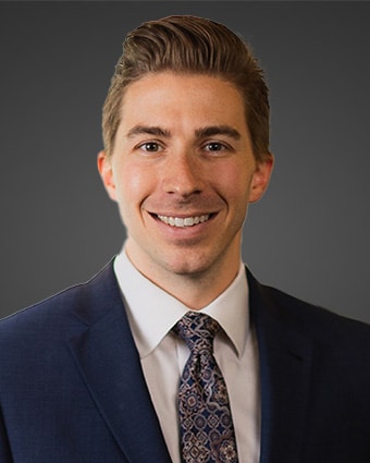 a man wearing a suit and tie smiling at the camera