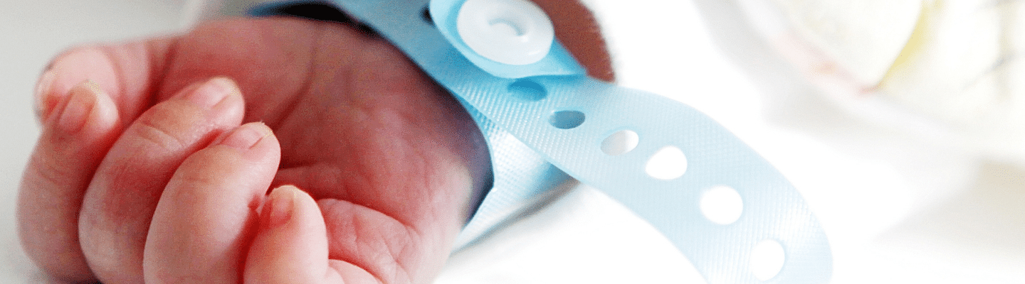 Image of an infant's arm with a medical bracelet