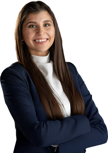 Professional woman in a navy suit smiling confidently with arms crossed on a neutral background.